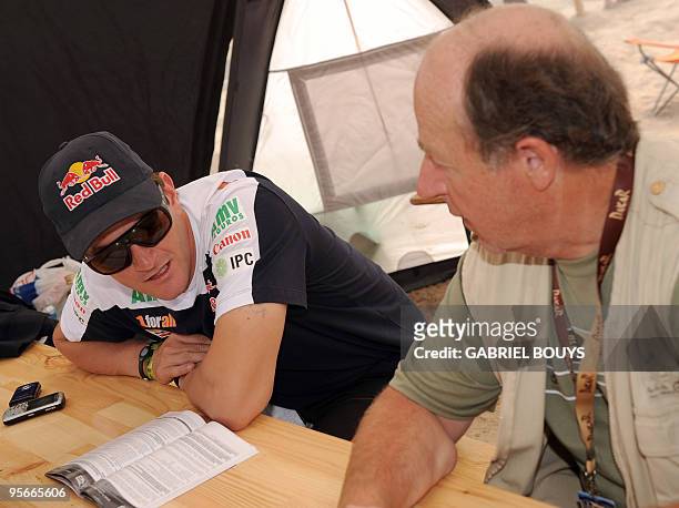 Spanish Marc Coma listens to moto race director Marc Ducrocq, during the resting day of the Dakar 2010, in Antofagasta, Chile, on January 9, 2010....