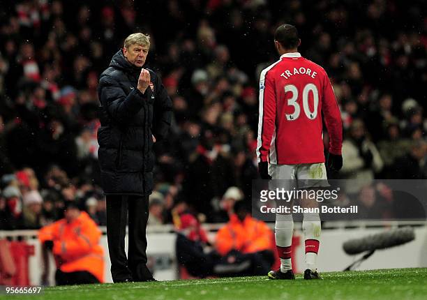 Manager of Arsenal Arsene Wenger speaks to Armand Traore of Arsenal during the Barclays Premier League match between Arsenal and Everton at Emirates...
