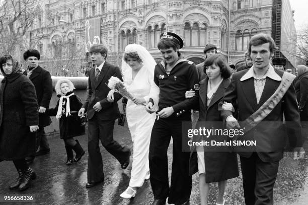 Un couple de marié sur la Place Rouge lors du 60ème anniversaire de la Révolution Russe le 7 novembre 1977 à Moscou, Russie.