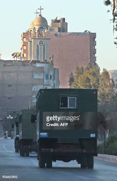 Police prison vehicles drive past a church in the southern Egyptian town of Nagaa Hammadi on January 9 two days after three gunmen sprayed Christian...