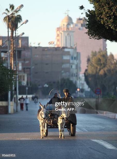 Man drives a donkey cart down a road near a Coptic church in the southern Egyptian town of Nagaa Hammadi on January 9 two days after three gunmen...