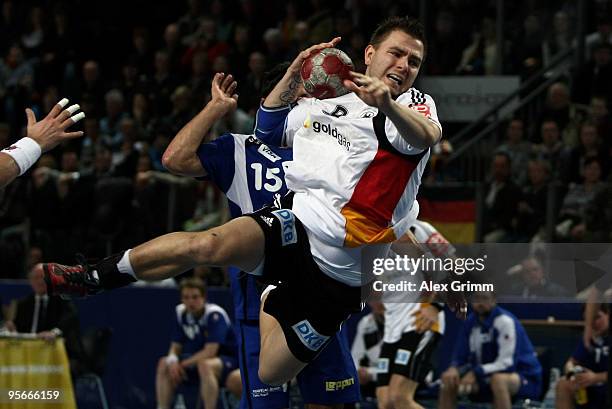 Christoph Teuerkauf of Germany is challenged by Alexander Petersson of Iceland during the international handball friendly match between Germany and...