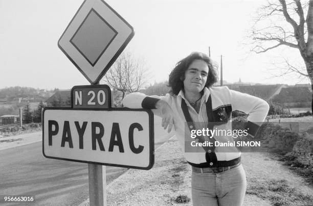 Le chanteur Nicolas Peyrac pose près de la pancarte d'un village qui porte son nom lors d'une tournée en mars 1976, France.