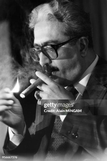 Portrait du vice-Premier ministre irakien Tarek Aziz allumant un cigare avec une allumette le 7 janvier 1983 à Paris, France.