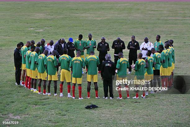 Nigerian Keshi Stephen head coach of Mali prays with his footballers during their training session at the Coqueiros stadium in Luanda, Angola on...