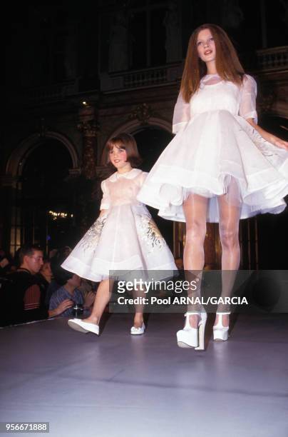 Le top model Kate Moss avec une petite fille lors du défilé Vivienne Westwood Prêt-à-porter Printemps-Eté 1993 en octobre 1992 à Paris, France.