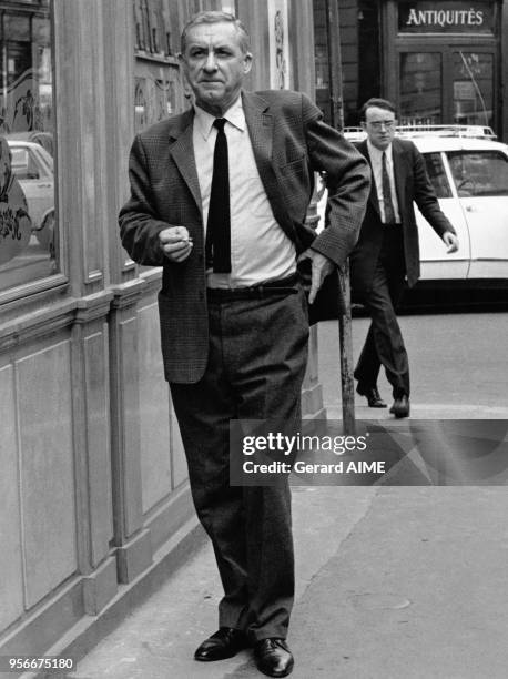 économiste français Jean Fourastié fumant une cigarette dans la rue en France.