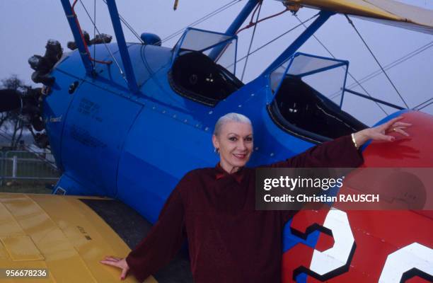 La mannequin française Colette Duval posant devant un avion sur une piste de l'aérodrome de la Ferté-Alais, en février 1986, dans l'Essone, France.