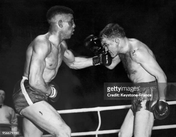 Le boxeur britannique Randy Turpin encaisse un direct au visage de son adversaire sur le ring, circa 1950.