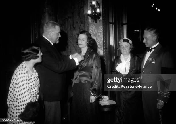 Le président de l'Aéro-Club de France, Monsieur Watteau décore Miss Jean Batten de la légion d'Honneur, à gauche Suzanne Deutsch de la Meurthe et à...