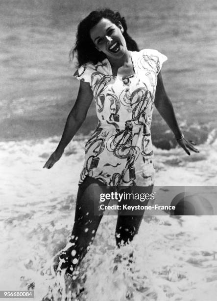 Actrice américaine Jane Russell en maillot de bain joue dans les vagues pendant ses vacances à la mer, circa 1940.