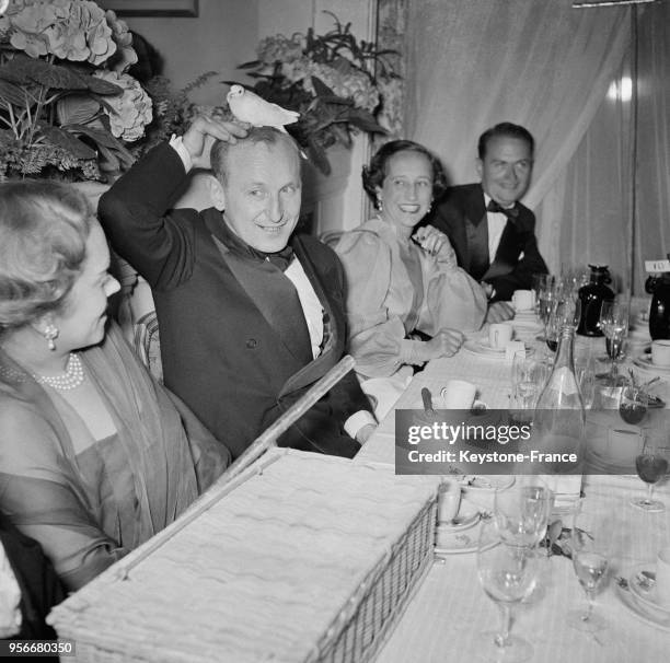 Soirée donnée sur le tournage du film 'Les trois mousquetaires' réalisé par André Hunebelle, Bourvil avec une colombe sur la tête en France, le 6 mai...