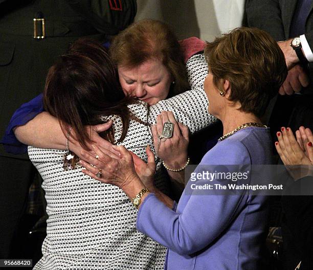 First Lady Laura Bush applauds as Janet Norwood, mother of Sgt. Byron Norwood, killed in Iraq, bends down to hug special guest Safia Taleb Suhail,...