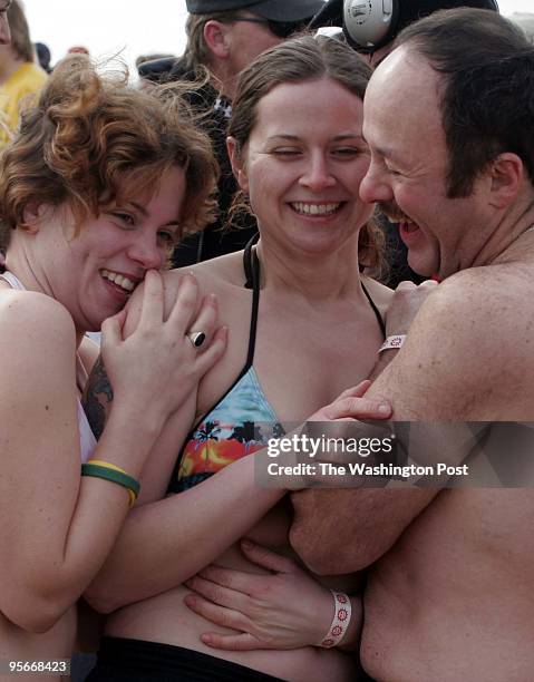 Hundreds participate in the 9th Annual Polar Bear Plunge. From left to right, Sarah Cover, Amanda Cover and Chris Foran cuddle to keep warm. They are...