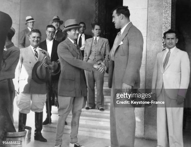 Ambassadeur américain Jefferson Caffery serre la main du boxeur italien Primo Carnera, circa 1930 à Cuba.