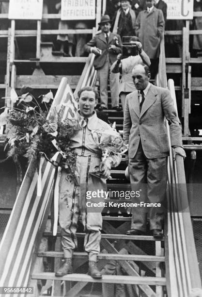 Le vainqueur Guy Moll descend de la tribune portant son trophée, à Monaco en avril 1934.