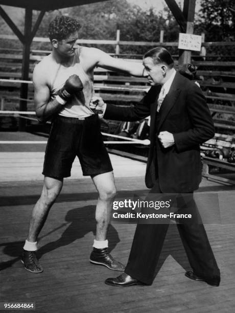 Le boxeur James J Corbett , ancien champion du monde poids lourds, photographié avec le géant argentin Vittorio Campolo, aux Etats-Unis en 1930.