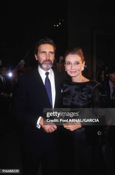 Portrait de l'actrice Audrey Hepburn et de son compagnon Robert Wolders assistant aux 40 ans de carrière du couturier Givenchy au musée Galliera en...