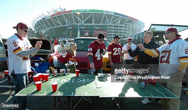 Chris Mitchell, left, of Annandale, Va. Takes aim while playing Beer Pong outside FedEx Field with his friends including Fred Lynch, far right, of...