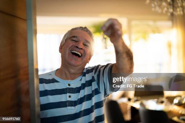 senior che mostra la casa chiave - solo un uomo anziano foto e immagini stock