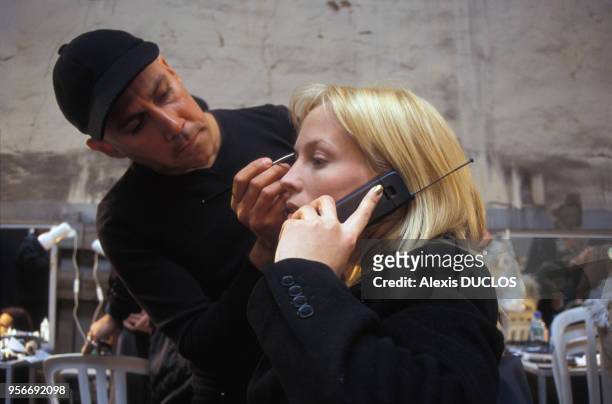 Séance de maquillage lors du défilé Enrica Massei Prêt-à-porter Automne-Hiver 1998-1999 en mars 1998 à Paris,France.