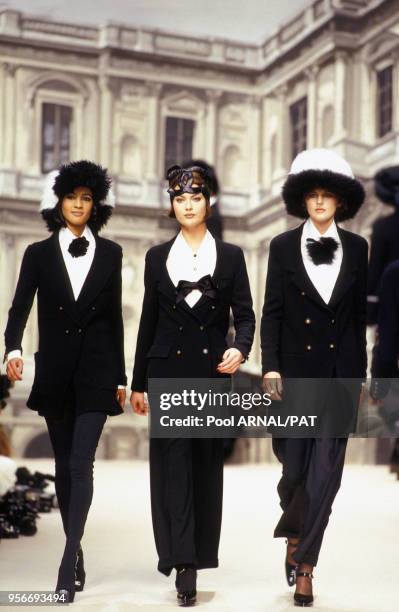 Mannequins portant des tenues élégantes en noir et blanc lors du défilé Chanel de prêt-à-porter de la collection automne-hiver en mars 1994 à Paris,...