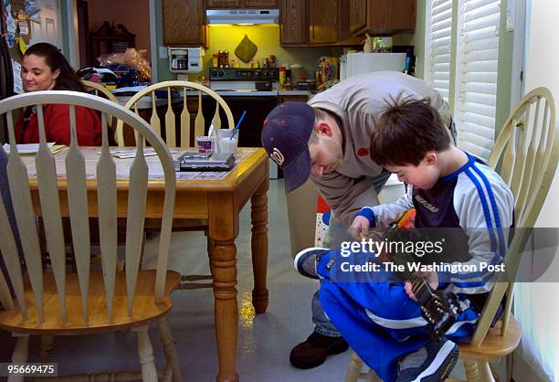 Bill Hutchison helps his son, Bill who has Down Syndrome, turn down his electric guitar. Michelle is at left.