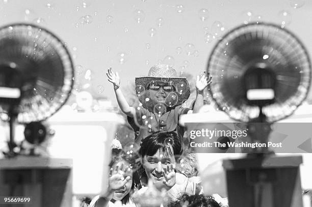 This is Steven Yu 3, on his father's shoulders. They are from Centerville, VA. They are enjoying one of several bubble machines that were on the...