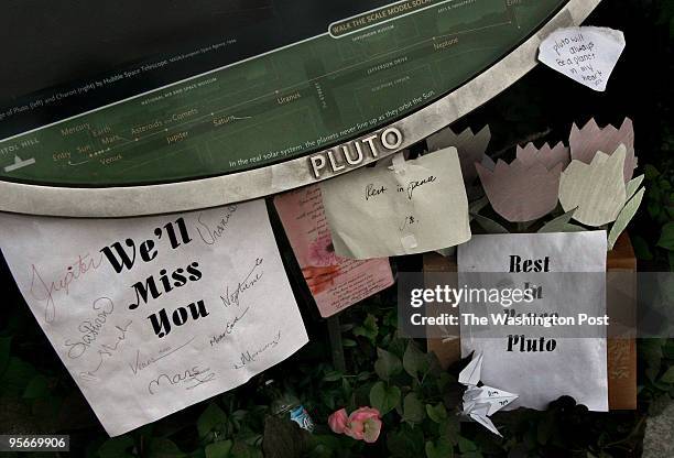 The Pluto Planet marker has several notes and cards attached and near to mourn it's loss as a full-fledged planet.