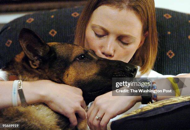 Shown is Jamie Dana, wounded Air Force dog handler kissing her bomb-sniffing dog, Rex inside her in-law's home in Wilkes-Barre, Pa.