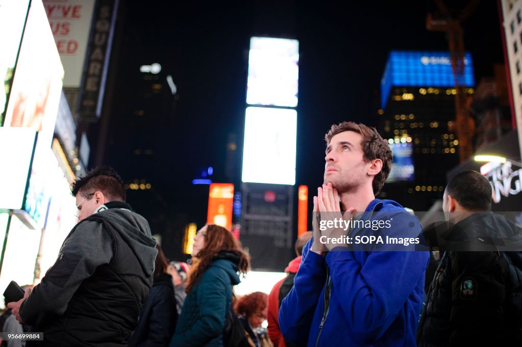 A young man watches incoming results on the giant screens of...