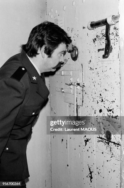 Un surveillant de prison regarde un prisonnier à l'intérieur d'une cellule en mars 1985 à Draguignan, France.