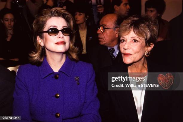 Les actrice Catherine Deneuve et Jeanne Moreau assistent au défilé Saint Laurent Haute Couture Printemps-Eté en janvier 1997, Paris, France.