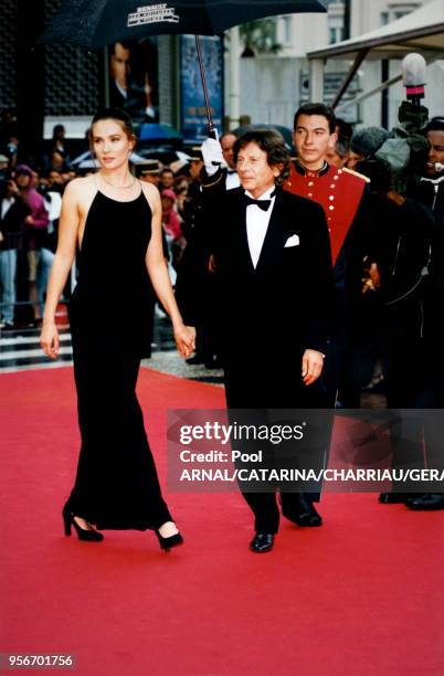 Emmanuelle Seigner et Roman Polanski main dans la main sur le tapis rouge au Festival de Cannes le 11 mai 1997, France.