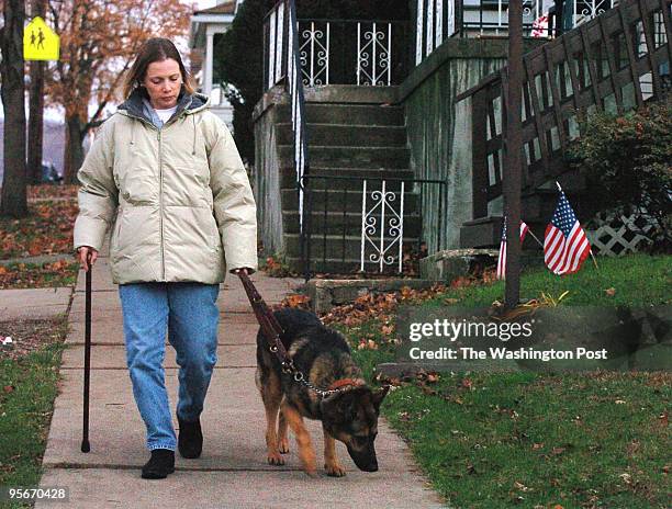 Shown is Jamie Dana, wounded Air Force dog handler walking with her bomb-sniffing dog, Rex outside her in-law's home in Wilkes-Barre, Pa.