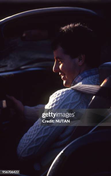 Le cycliste irlandais Stephen Roche conduisant une voiture de collection.