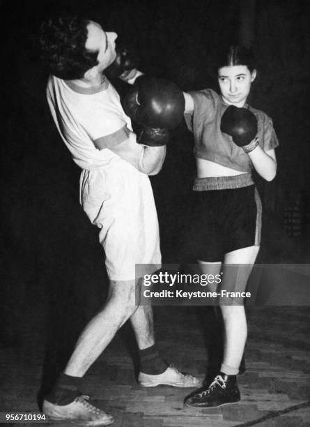 La première boxeuse au monde, Barbara Buttrick, s'entraîne avec ardeur contre un homme au Royaume-Uni.