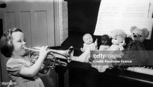 Helen Crayford, 4 ans et fille du trompettiste professionnel Marshall Crayford, joue de la trompette pour ses poupées et ses ours en peluche alignés...
