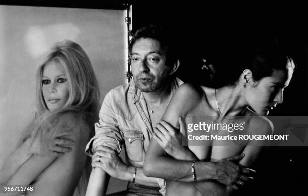 Serge Gainsbourg et sa compagne Bambou qui reprend la pose d'un portrait de Brigitte Bardot chez lui à Paris, France.