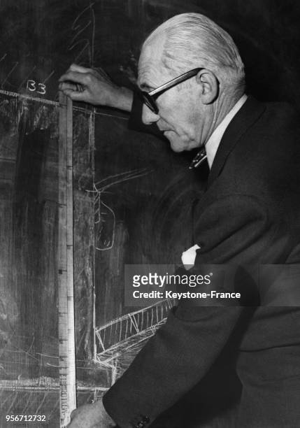 Sur un des grands tableaux noirs de son atelier, Le Corbusier prend des mesures au moyen du 'Modulor', mesure harmonique à l'échelle humaine...