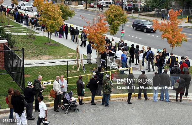 Voters wait in line to cast their votes at Bell Multicultural High School on 16th St. N.W. Here on 16th st. The line curves into a parking lot.