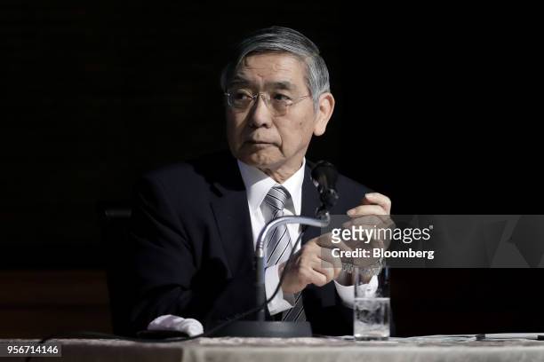 Haruhiko Kuroda, governor of the Bank of Japan , puts on a wristwatch as he prepares to leave following his speech at an event in Tokyo, Japan, on...