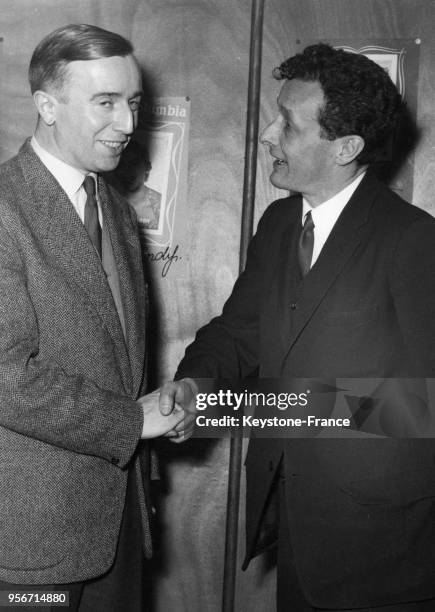 Jean-Louis Barrault serrant la main d'Albert Husson, à Paris, France en janvier 1956.