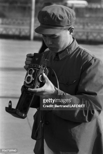 Un homme en costume Mao prend des photos sur la Place Tian'anmen en février 1982 à Pékin, Chine.