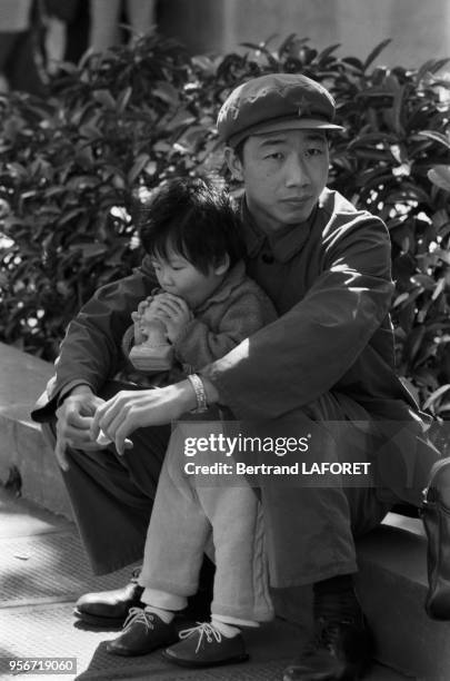 Un père avec sa petite fille assis dans un jardin public en février 1982 à Shanghai, Chine.