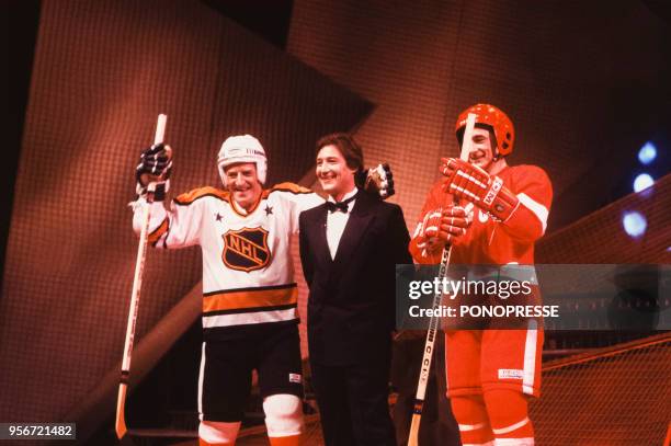 Animateur Patrick Sabatier avec deux joueurs de hockey lors d'une soirée en février 1987 à Montréal, Canada.