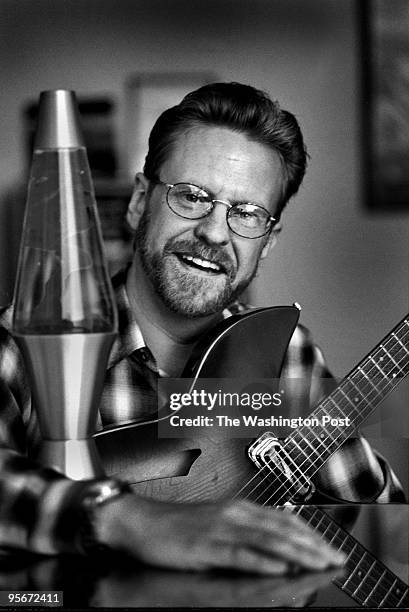 John Sidgmore, president of UUNET is shown with his guitar, Jimmi Hendrix poster, and operating Lava Lamp in his Fairfax office.