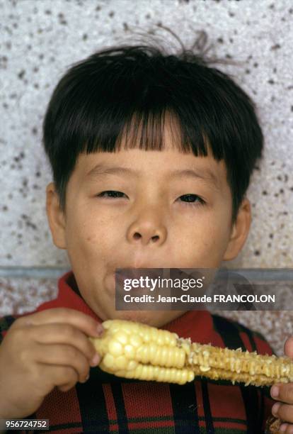 Petit garçon mangeant du maïs en 1974 à Taïwan.