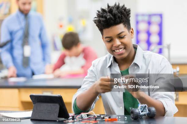 teenager genießt bauen einen roboter in der schule - plant stem stock-fotos und bilder