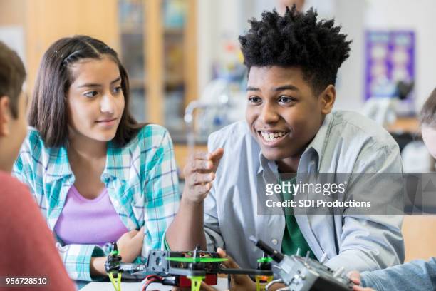 teenager bespricht projekt mit klassenkameraden im robotiklabor - plant stem stock-fotos und bilder